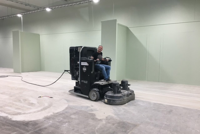 a man riding an HTC 1500 ride on concrete polishing and grinding machine NZ Grinders