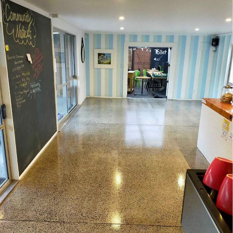 A cafe cloor with a topical coat concrete sealed floor and blue and white striped wall with a chalkboard menu on left wall