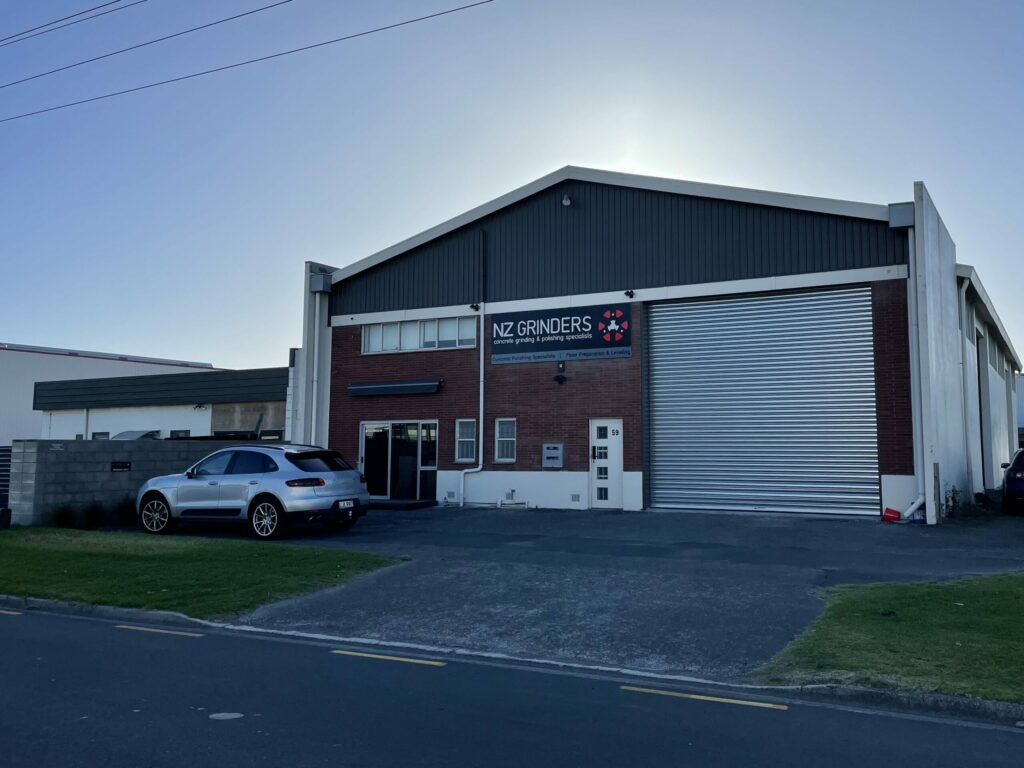 Image of exterior building showroom NZ Grinders a two strey warehouse with a brick facade and a car parked out the front