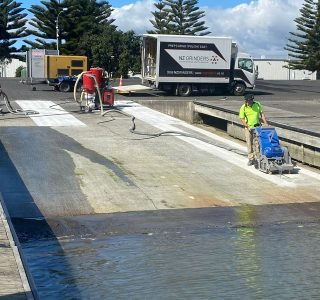 A concrete planer machine working on a boat ramp to add texture to concrete for non-slip
