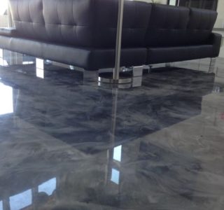marble effect epoxy floor in lounge area under a sofa in grey swirl tones