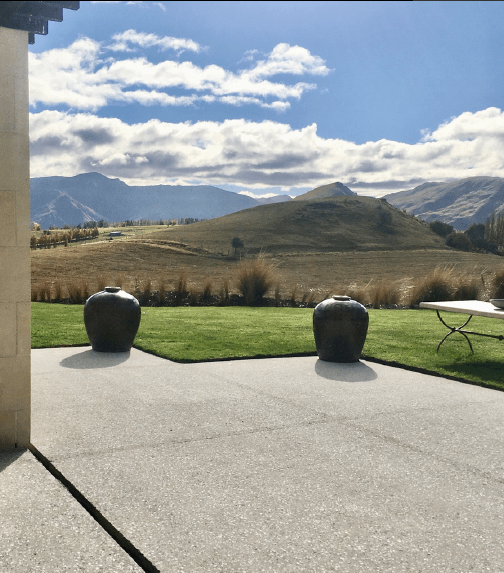 outdoor polished concrete floor with 2 pots in background and a view of a mountain