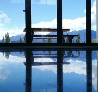 image of windows from a lounge with snow capped mountains in the background and a gleaming polished concrete floor