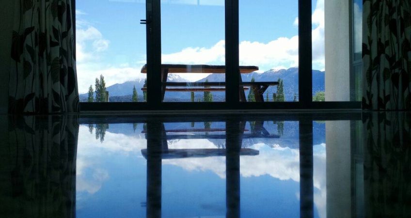 image of windows from a lounge with snow capped mountains in the background and a gleaming polished concrete floor