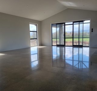 Polished concrete floor in partly built house lounge empty room