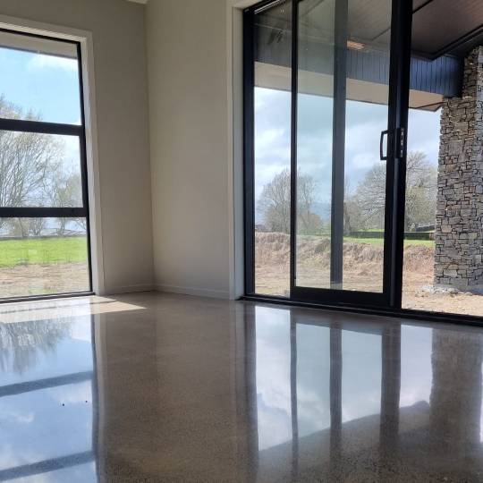 Salt and pepper finish for a beach house polished concrete floor nz grinders tauranga living room