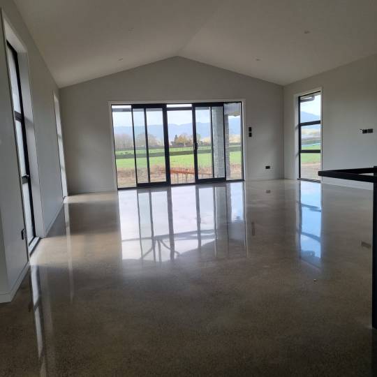 Salt and pepper finish for a beach house polished concrete floor nz grinders tauranga lounge area